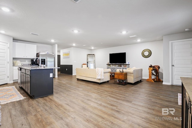 living room with light hardwood / wood-style flooring and sink