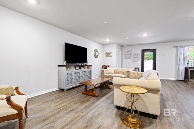 living room with hardwood / wood-style floors and a textured ceiling