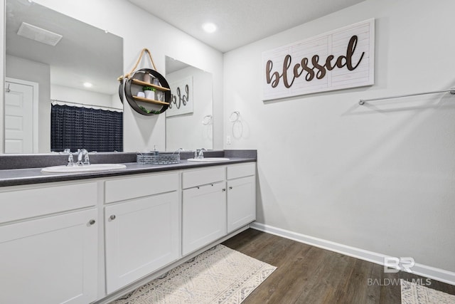 bathroom featuring walk in shower, vanity, and hardwood / wood-style flooring