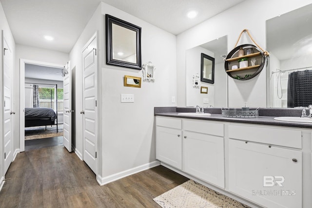 bathroom with curtained shower, vanity, wood-type flooring, and a textured ceiling