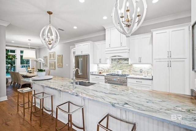 kitchen with appliances with stainless steel finishes, a kitchen breakfast bar, dark wood-type flooring, sink, and white cabinetry