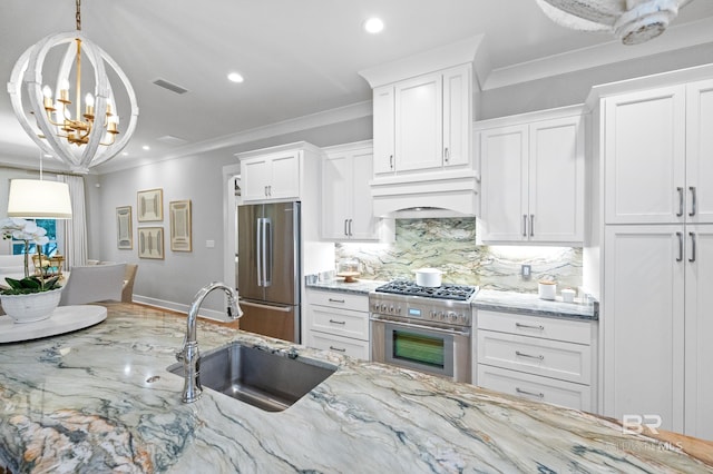 kitchen featuring sink, white cabinets, stainless steel appliances, and decorative light fixtures