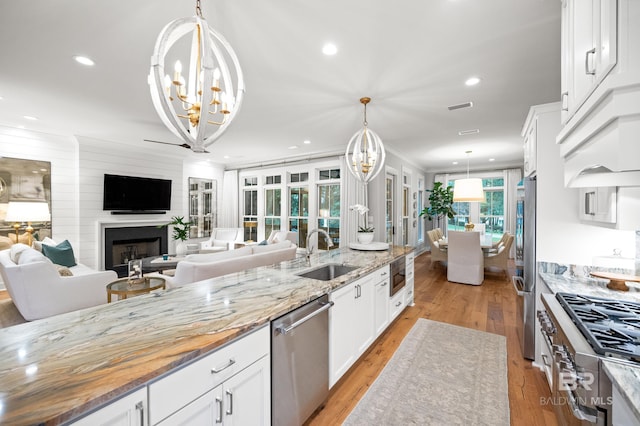 kitchen with white cabinets, pendant lighting, sink, and stainless steel appliances