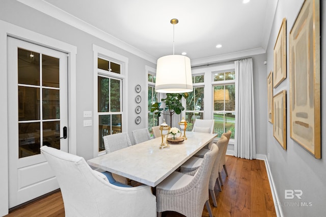 dining space featuring light hardwood / wood-style floors and crown molding