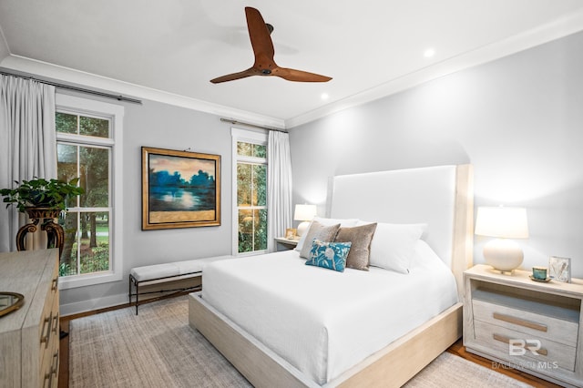 bedroom with ceiling fan, ornamental molding, and light hardwood / wood-style flooring