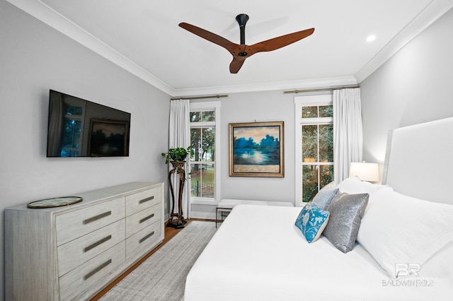 bedroom with multiple windows, ceiling fan, light hardwood / wood-style flooring, and ornamental molding