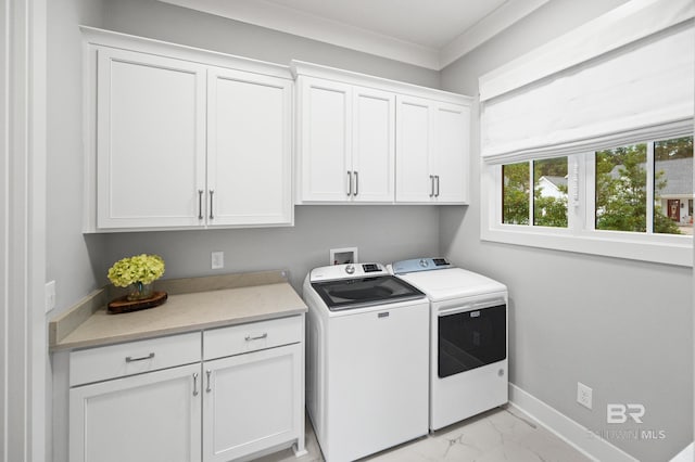 laundry area with washer and clothes dryer, cabinets, and crown molding