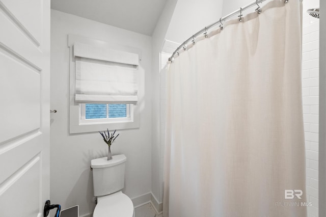 bathroom featuring a shower with shower curtain and toilet