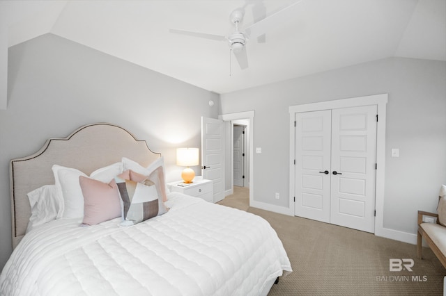 carpeted bedroom with ceiling fan, a closet, and lofted ceiling