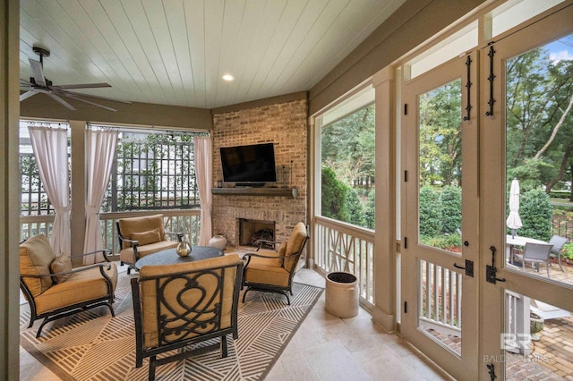 sunroom / solarium featuring a fireplace, ceiling fan, and wooden ceiling