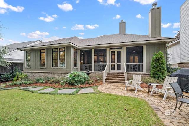 rear view of property with a sunroom, a yard, and a patio