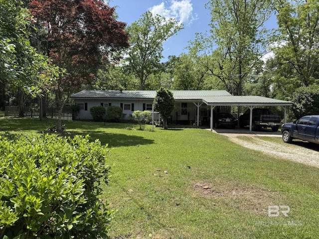 ranch-style house with metal roof, a carport, a front lawn, and driveway