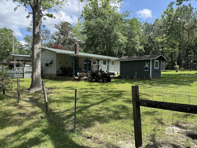 view of front of property featuring a chimney, an outbuilding, a front lawn, and fence