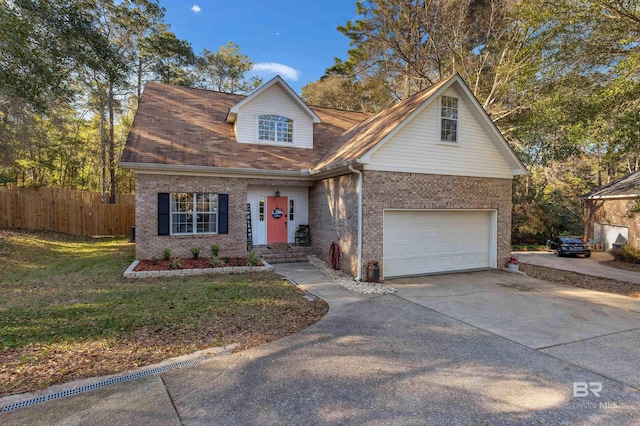 view of front of house with concrete driveway, brick siding, a front lawn, and fence