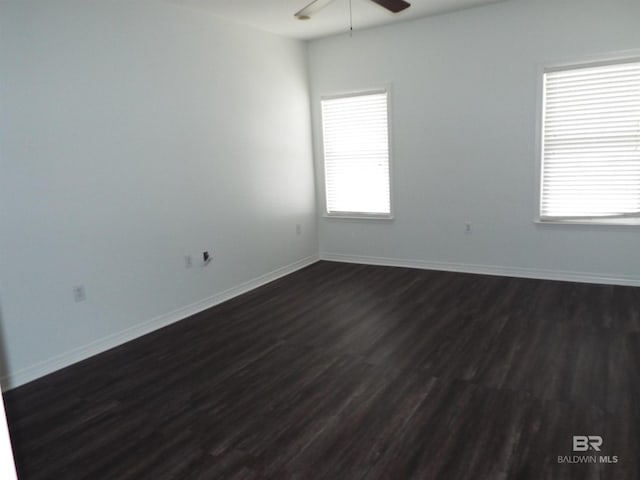 empty room with dark hardwood / wood-style floors and ceiling fan