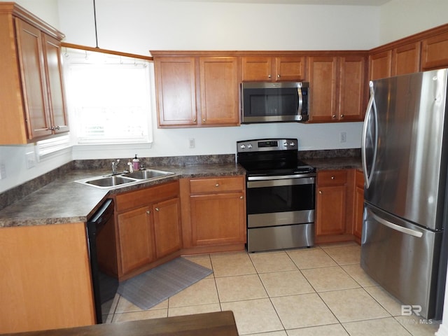 kitchen with light tile patterned flooring, appliances with stainless steel finishes, and sink