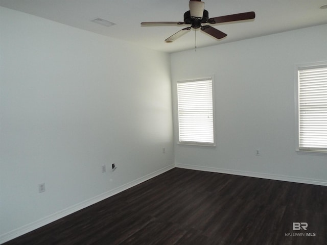 spare room featuring ceiling fan and dark wood-type flooring