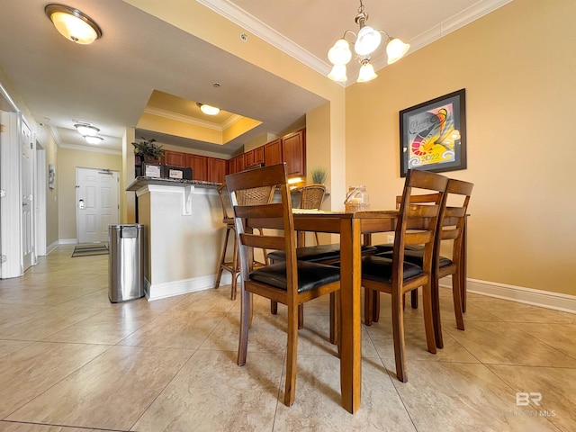 dining space with baseboards, ornamental molding, a raised ceiling, and light tile patterned floors