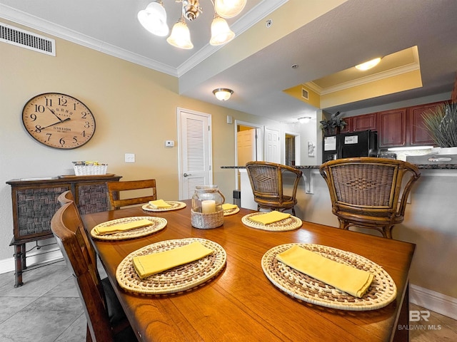 dining area featuring crown molding, a notable chandelier, visible vents, and baseboards