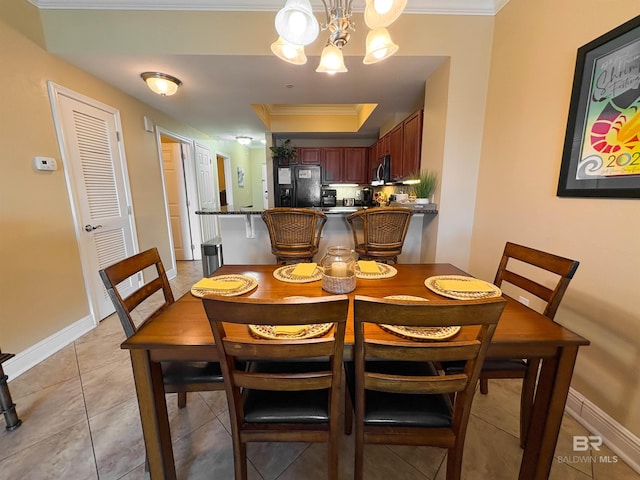 dining room featuring crown molding, baseboards, an inviting chandelier, and light tile patterned floors