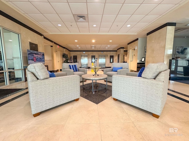 living room featuring light tile patterned floors, a drop ceiling, a tray ceiling, and visible vents