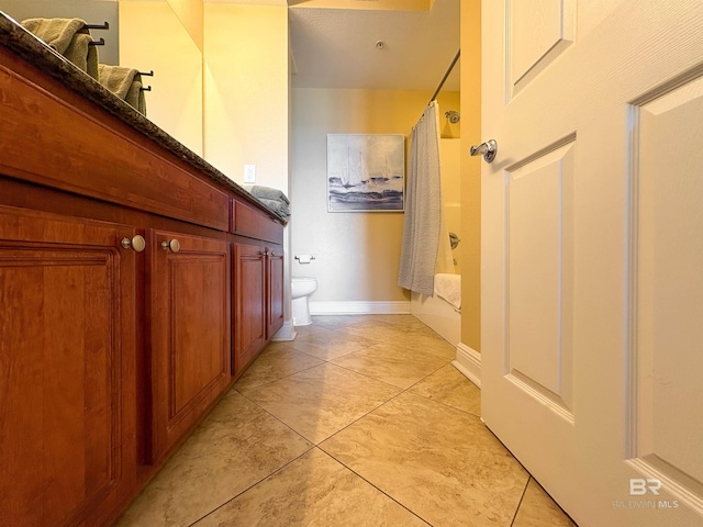 bathroom featuring vanity, tile patterned floors, shower / bath combination with curtain, and toilet
