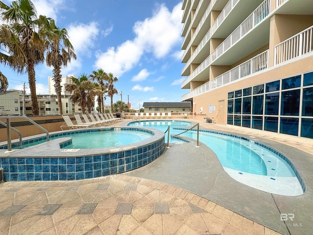 pool with a patio and a community hot tub