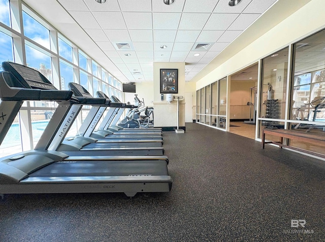 gym with a paneled ceiling and visible vents