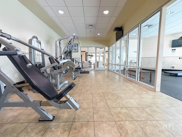 workout area featuring tile patterned floors and a paneled ceiling