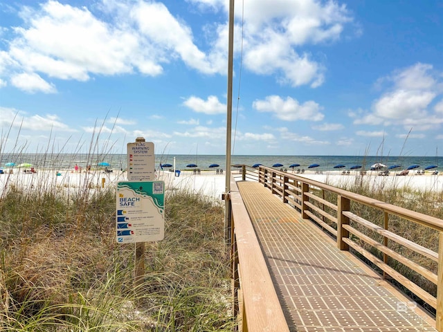 view of home's community with a water view and a beach view