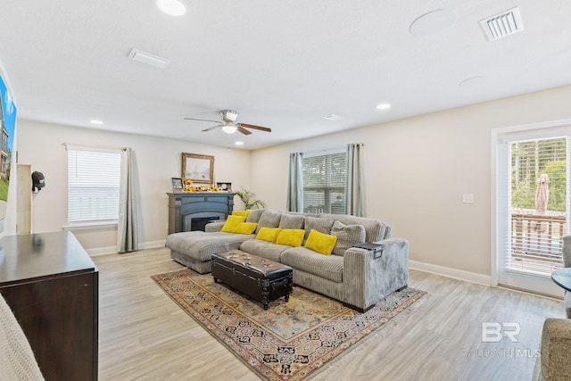 living room featuring light hardwood / wood-style floors and ceiling fan