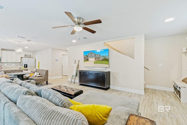 living room featuring light hardwood / wood-style floors and ceiling fan