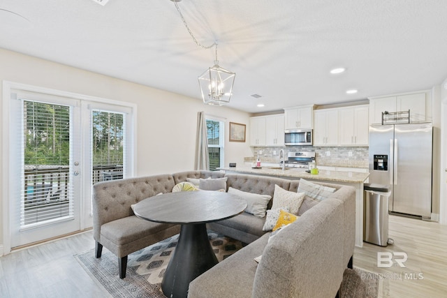 dining area with light hardwood / wood-style flooring and an inviting chandelier