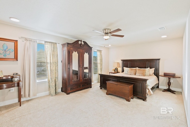 bedroom with multiple windows, ceiling fan, and light colored carpet