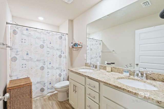 full bathroom featuring wood-type flooring, vanity, toilet, and shower / bathtub combination with curtain