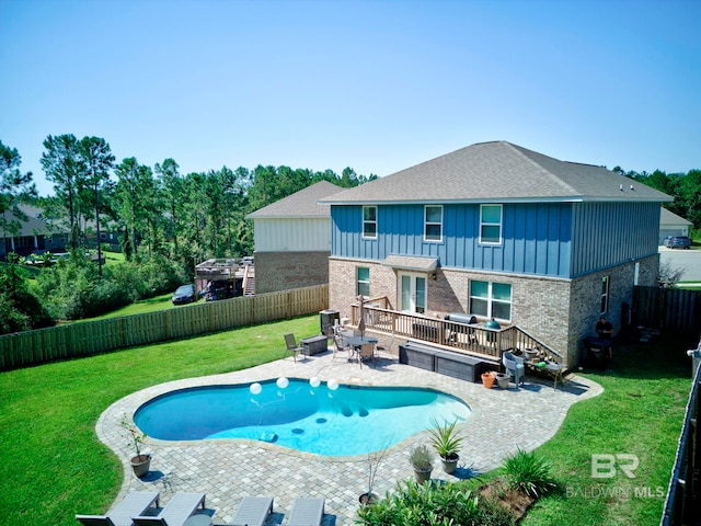 view of swimming pool featuring a wooden deck, a yard, and a patio area