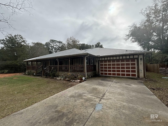 view of front of home featuring a front yard, a porch, and a garage