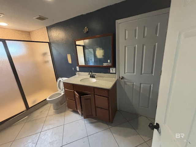 bathroom with toilet, vanity, tile patterned floors, and a shower with door