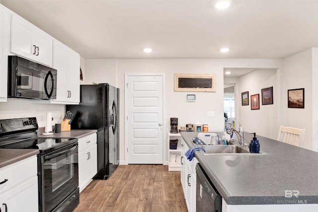 kitchen with white cabinetry, sink, black appliances, and hardwood / wood-style flooring