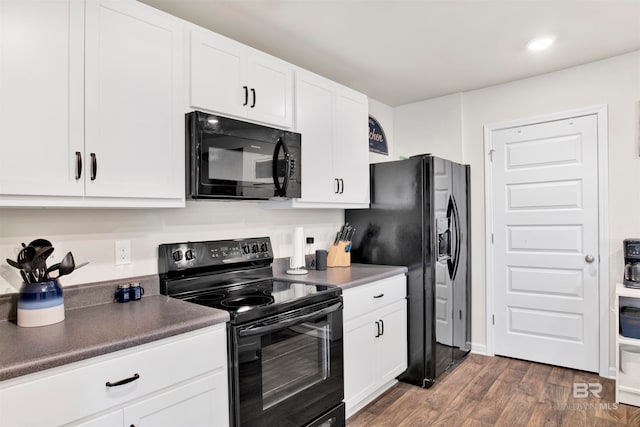 kitchen with black appliances, dark hardwood / wood-style flooring, and white cabinets