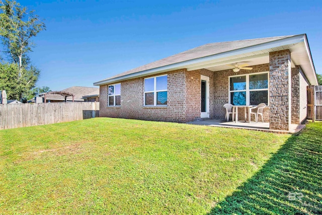 rear view of house featuring a patio, ceiling fan, and a lawn