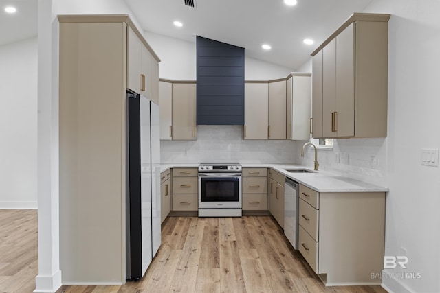 kitchen with light countertops, backsplash, appliances with stainless steel finishes, a sink, and exhaust hood