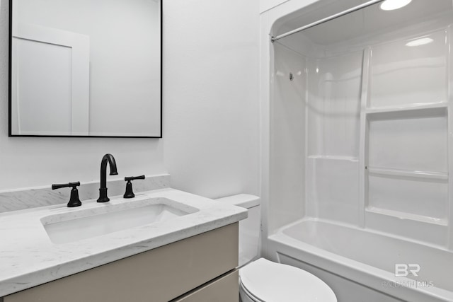 bathroom featuring bathtub / shower combination, vanity, and toilet