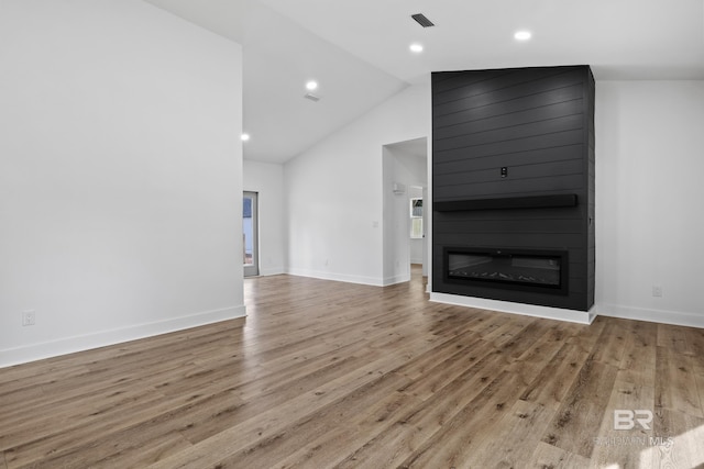 unfurnished living room featuring light wood-style floors, visible vents, a fireplace, and baseboards