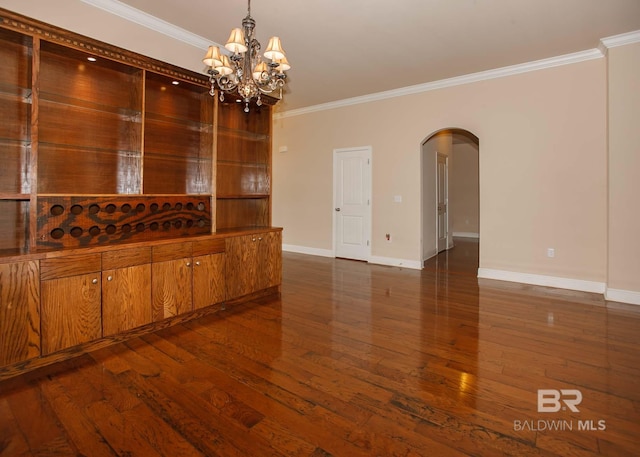 empty room featuring ornamental molding, dark hardwood / wood-style floors, and a chandelier