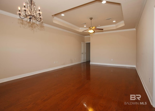 unfurnished room featuring a raised ceiling, ornamental molding, ceiling fan with notable chandelier, and dark hardwood / wood-style flooring