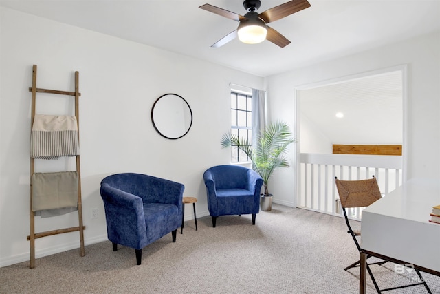 living area with a ceiling fan, baseboards, and carpet floors