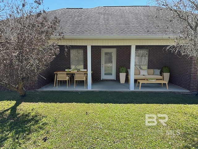 16825 Edward Dr, Gulf Shores, AL 36542 - rear view of house featuring a patio area, a lawn, a shingled roof, and brick siding