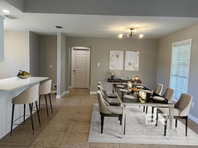 16825 Edward Dr, Gulf Shores, AL 36542 - dining space featuring baseboards, light tile patterned flooring, and a chandelier