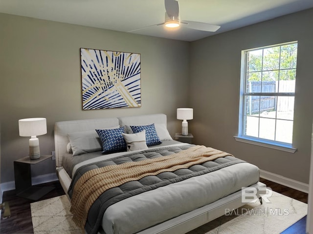 16825 Edward Dr, Gulf Shores, AL 36542 - bedroom featuring baseboards, multiple windows, and dark wood-type flooring